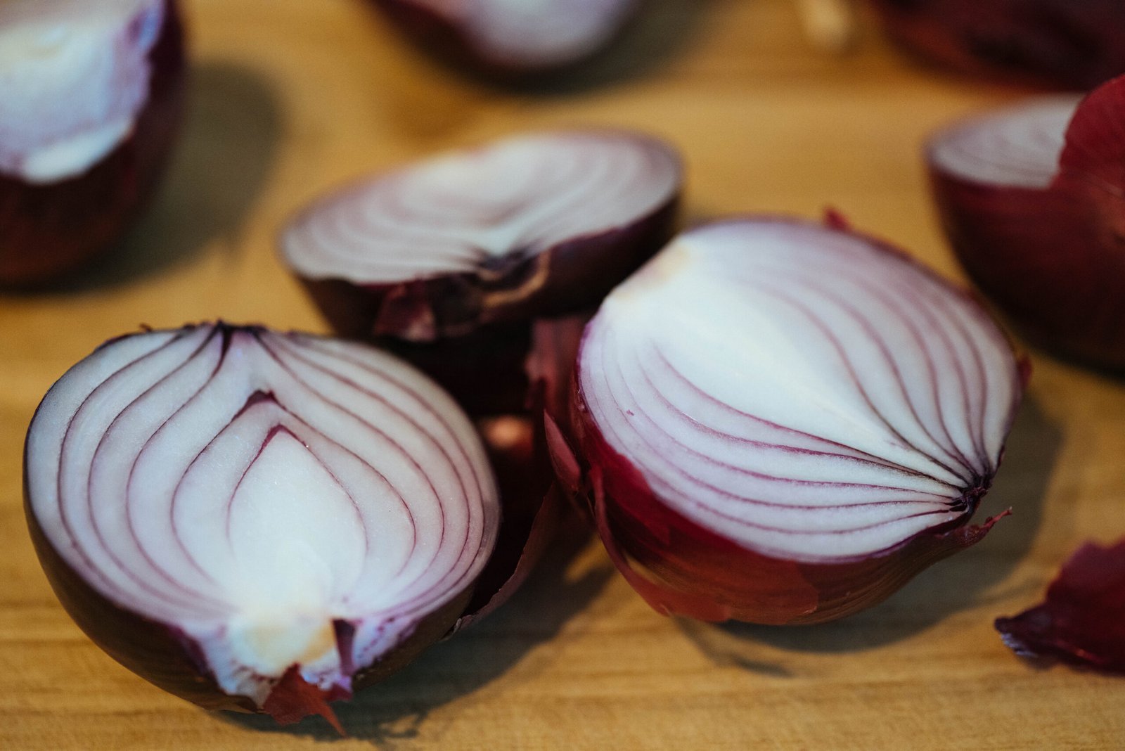 Red onions halved on a cutting board